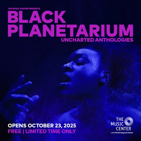 A black, blue, and pink promotional poster for The Music Center's upcoming exhibition, "Black Planetarium: Uncharted Territories." The poster depicts a photograph of an individual seemingly underwater, with blue skin, overlayed with pink text of the exhibition title, date, and location.
